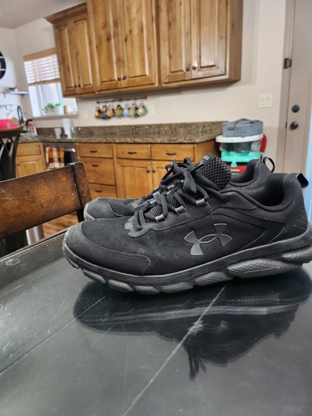 Men's black UnderArmour "Charged Assert" shoes (reg width)